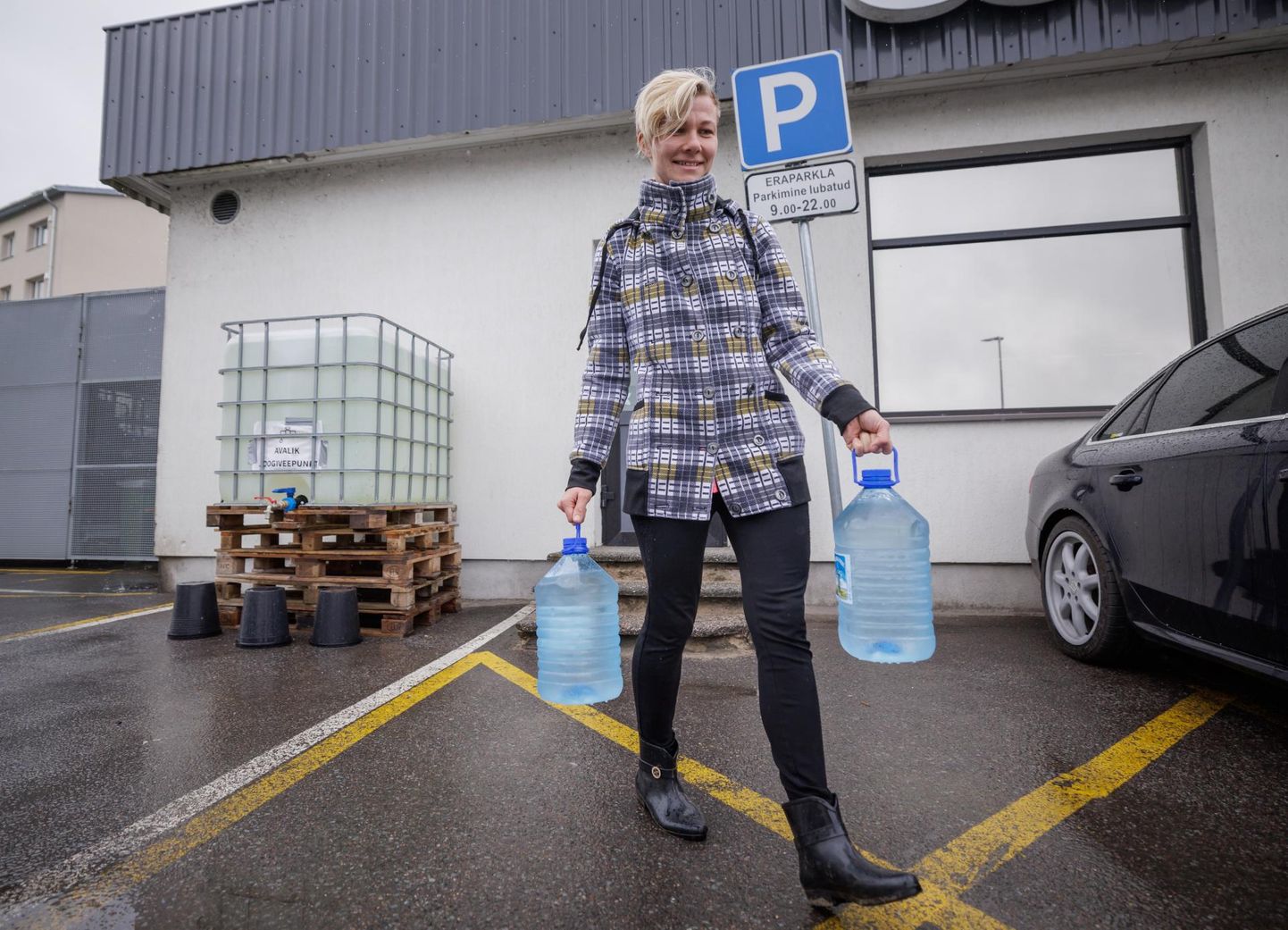 Kuressaare elanik Kersti Ränk on Coopi Tooma poe juures täitnud veepaagist kaks jooginõu, et viia puhast vett koju lastele.