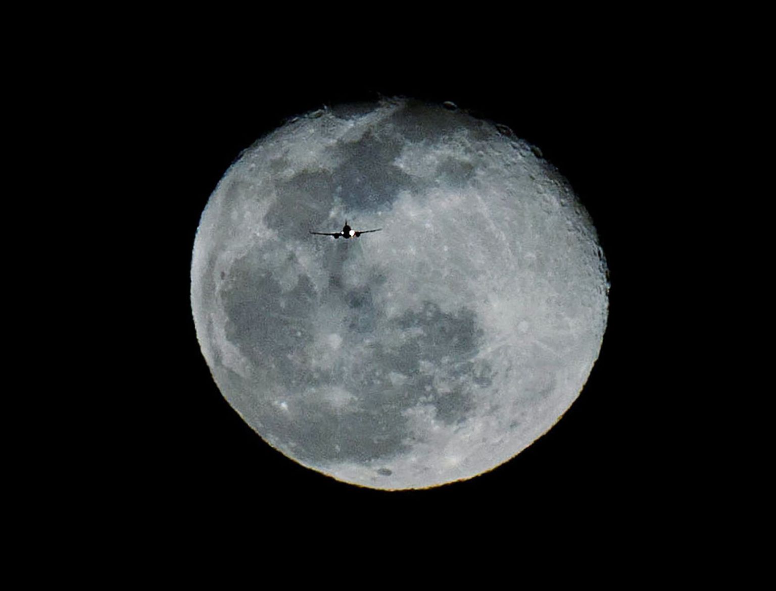 February 28, 2021, California, USA: Southwest flight 1077 flying from Phoenix to Ontario is silhouetted in front of an almost full Moon in Moreno Valley on Sunday, February 28, 2021. (Credit Image: © Terry Pierson/Orange County Register via ZUMA Wire)