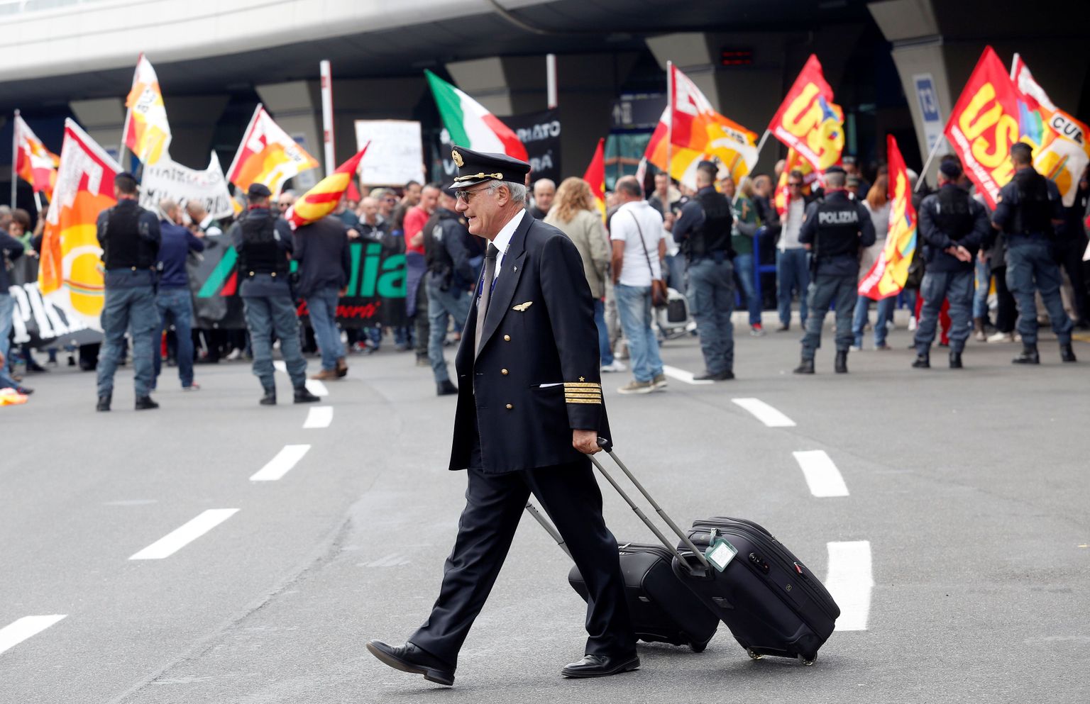 Alitalia lennumeeskonna liige möödub lennukompanii streikivatest töötajatest.