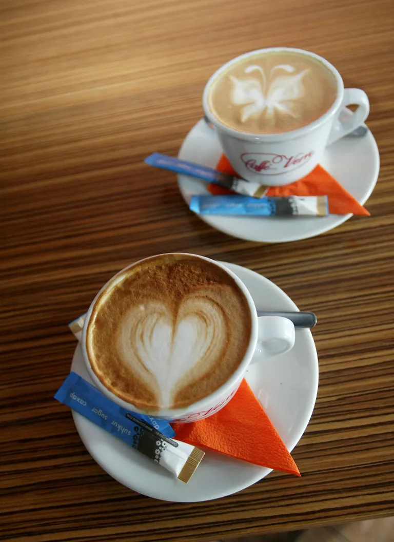 Osav barista joonistab cappuccinole peale kauni mustri.