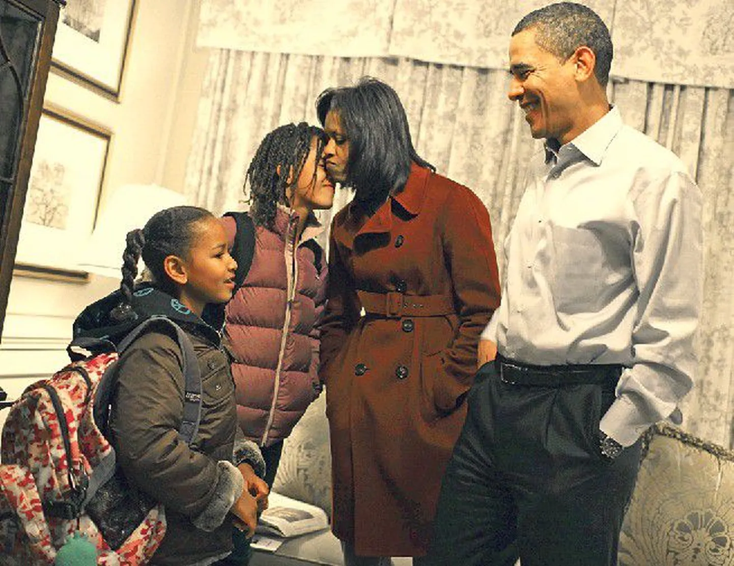 Мишель и Барак Обама провожают в школу двух своих дочек.