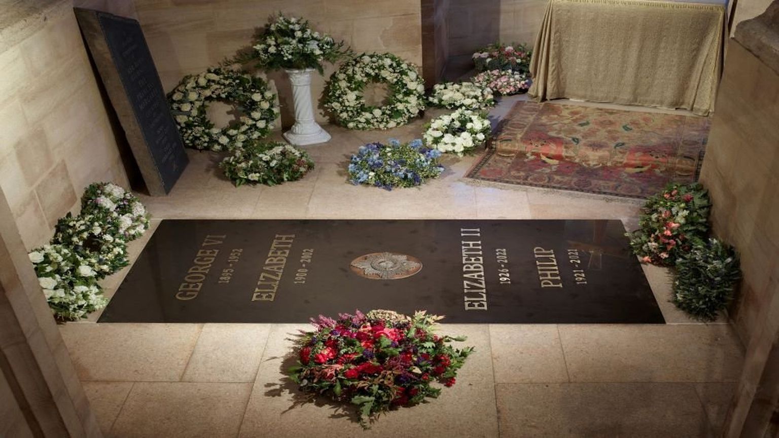 Черный надгробный камень установлен в полу мемориальной часовни Георга VI, где в понедельник была похоронена королева.