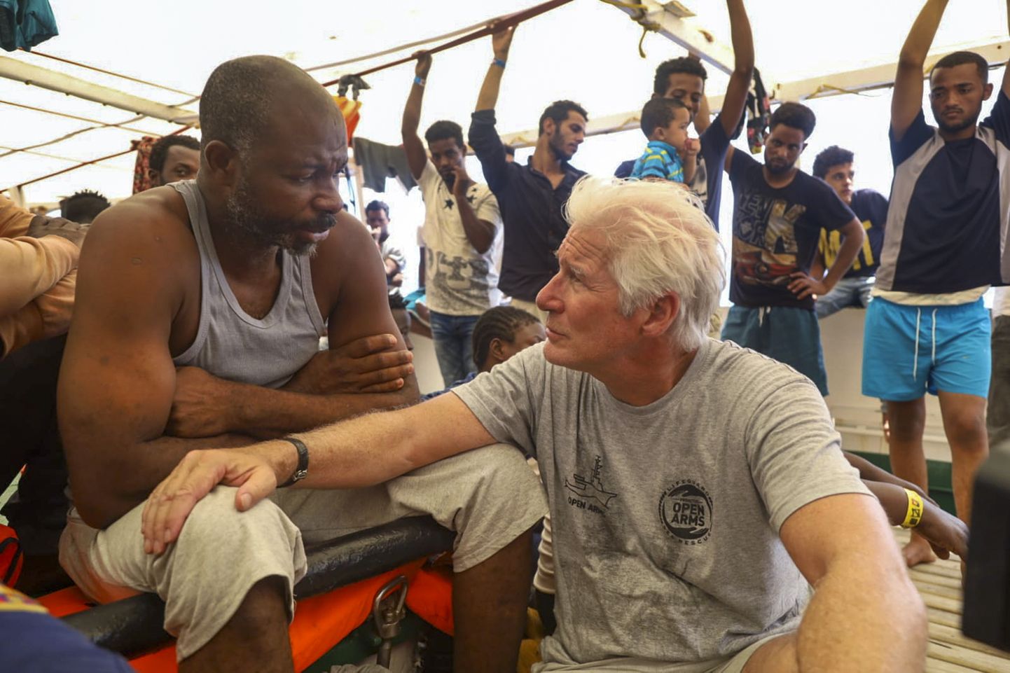 Näitleja Richard Gere (paremal) vestlemas migrantidega Hispaania päästelaeva Open Arms pardal Lampedusa saare lähistel Vahemerel. Alus on juba kümmekond päeva oodanud randumiseks Itaalia võimude luba.