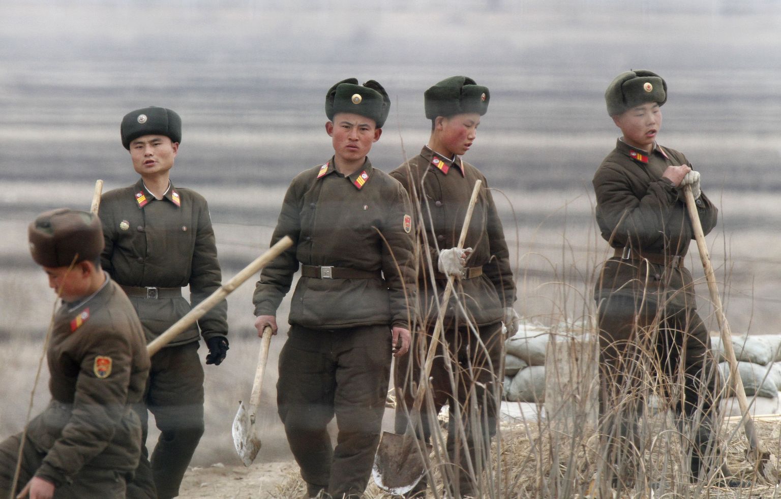 North Korean soldiers are seen through fences as they work with shovels on Hwanggumpyong Island, located in the middle of the Yalu River, near the North Korean town of Sinuiju, opposite the Chinese border city of Dandong, April 13, 2013. U.S. Secretary of State John Kerry met China's top leaders on Saturday in a bid to persuade them to exert pressure on North Korea to scale back its belligerent rhetoric and, eventually, return to nuclear talks. REUTERS/Jacky Chen (NORTH KOREA - Tags: POLITICS MILITARY)