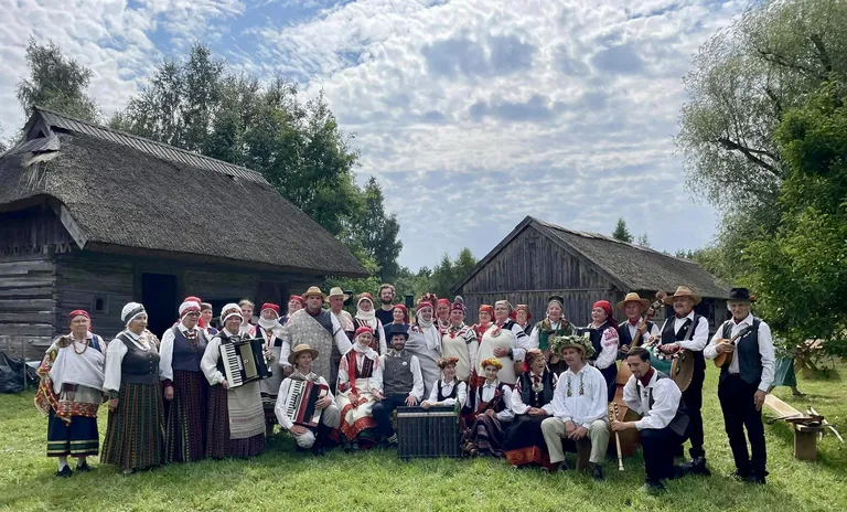 Jaunais pāris, kāzinieki un kāzu muzikanti.