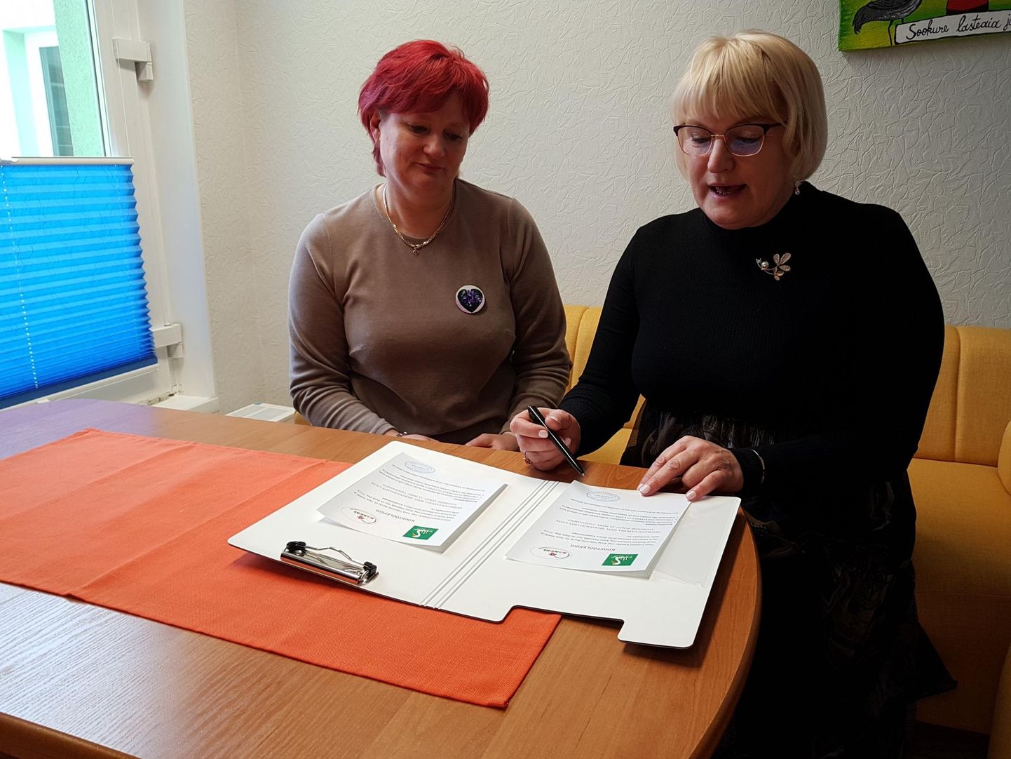 Tartu Kannikese lasteaia direktor Ülle Västik (vasakul) ja Paide Sookure lasteaia direktor Liia Koppel kirjutavad alla koostöölepingule, mis peaks tooma uut hingamist mõlemale lasteaiale.