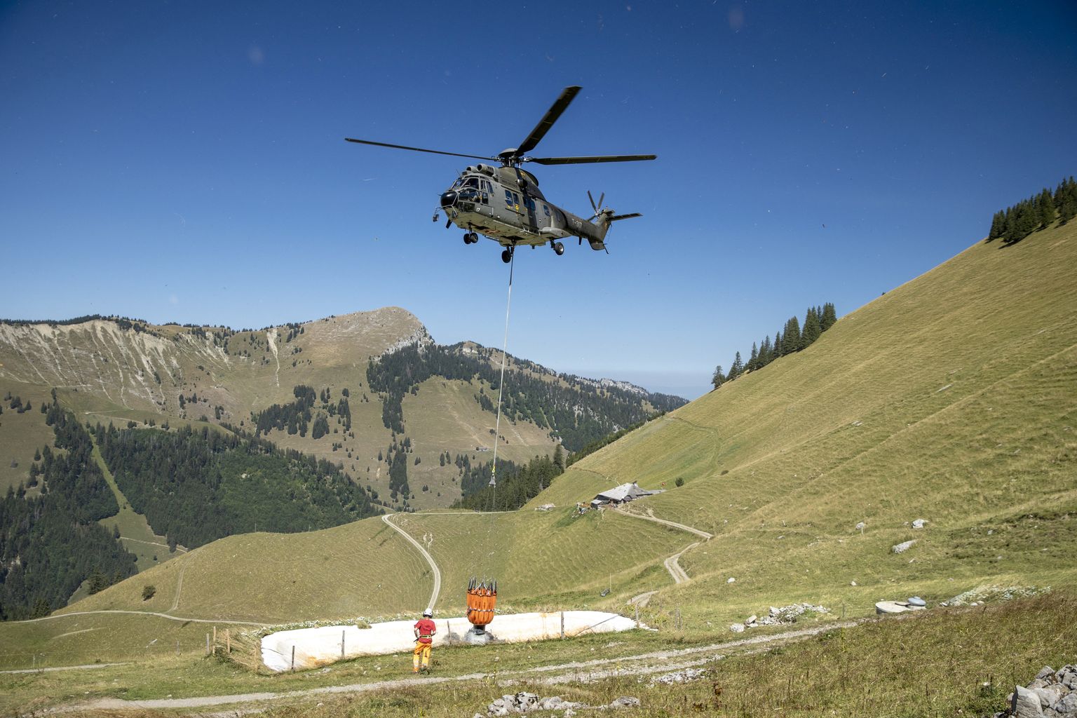 Šveitsi õhuväe Super Puma helikopter viib vette lehmadele Tissiniva mägikarjamaal Val-de-Charmey piirkonnas.