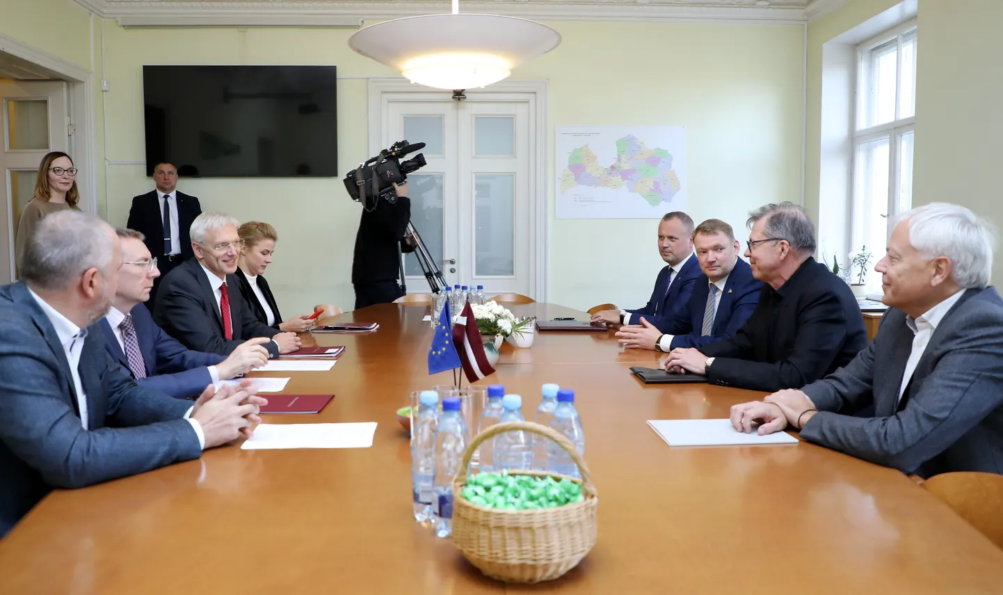 Partijas "Jaunā vienotība" pārstāvji - Valmieras novada domes priekšsēdētājs Jānis Baiks (no kreisās), ārlietu ministrs Edgars Rinkēvičs, Ministru prezidents Krišjānis Kariņš, Ministru prezidenta parlamentārā sekretāre Evika Siliņa un "Apvienotais saraksts" pārstāvji - "Latvijas Liepājas partija" līdzpriekšsēdētājs, "Latvijas Zaļā partija" vadītājs un 13. Saeimas deputāts Edgars Tavars, "Latvijas Reģionu apvienība" valdes priekšsēdētājs Edvards Smiltēns, Ministru prezidenta amata kandidāts Uldis Pīlēns un Liepājas partijas priekšsēdētājs Uldis Sesks tikšanās laikā, kurā pārrunās jaunās valdības prioritātes un darāmos darbus 14. Saeimā.