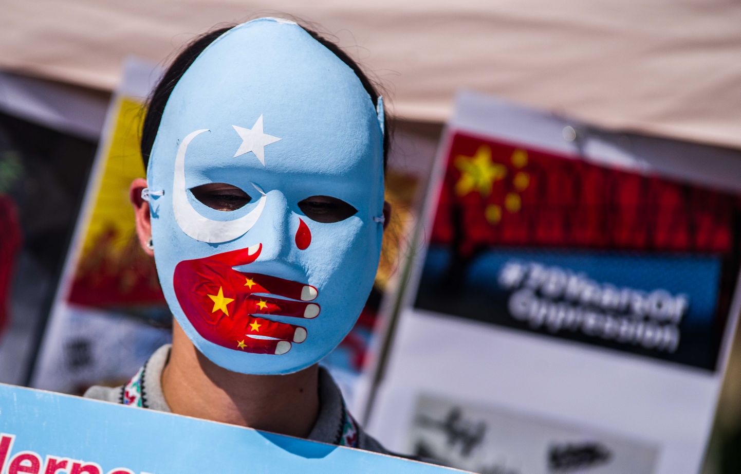 Ida-Turkestani ja Hiina lipu värvide ja sümbolitega maski kandev meeleavaldaja Münchenis protestib uiguuride olukorra halvenemise vastu Hiinas Xinjiangi piirkonnas 8. august 2020.