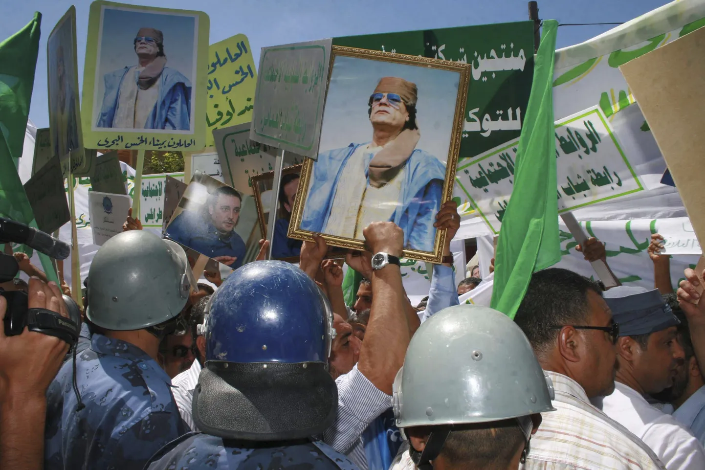 Liibüa meeleavaldajad Muammar Gaddafi plakatitega Šveitsi saatkonna ees Tripolis.