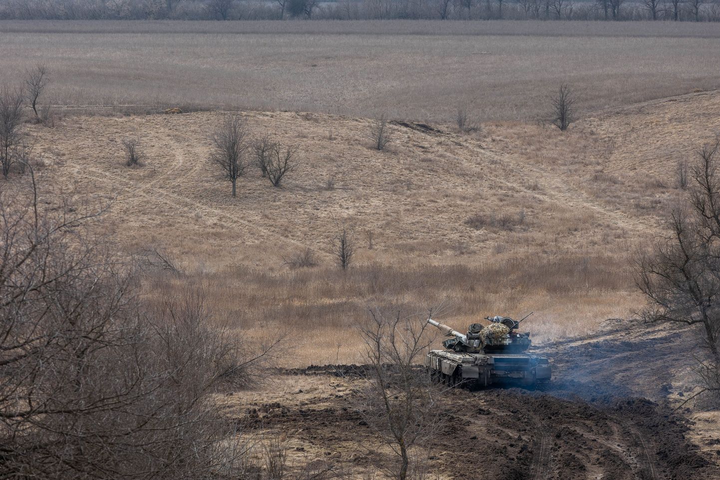 Танк Т-64 1-й танковой бригады Украины на юге Донбасса под Угледаром. Хорошо видны обширные поля, на которых там ведутся бои. Поля окружены узкими рядами деревьев.