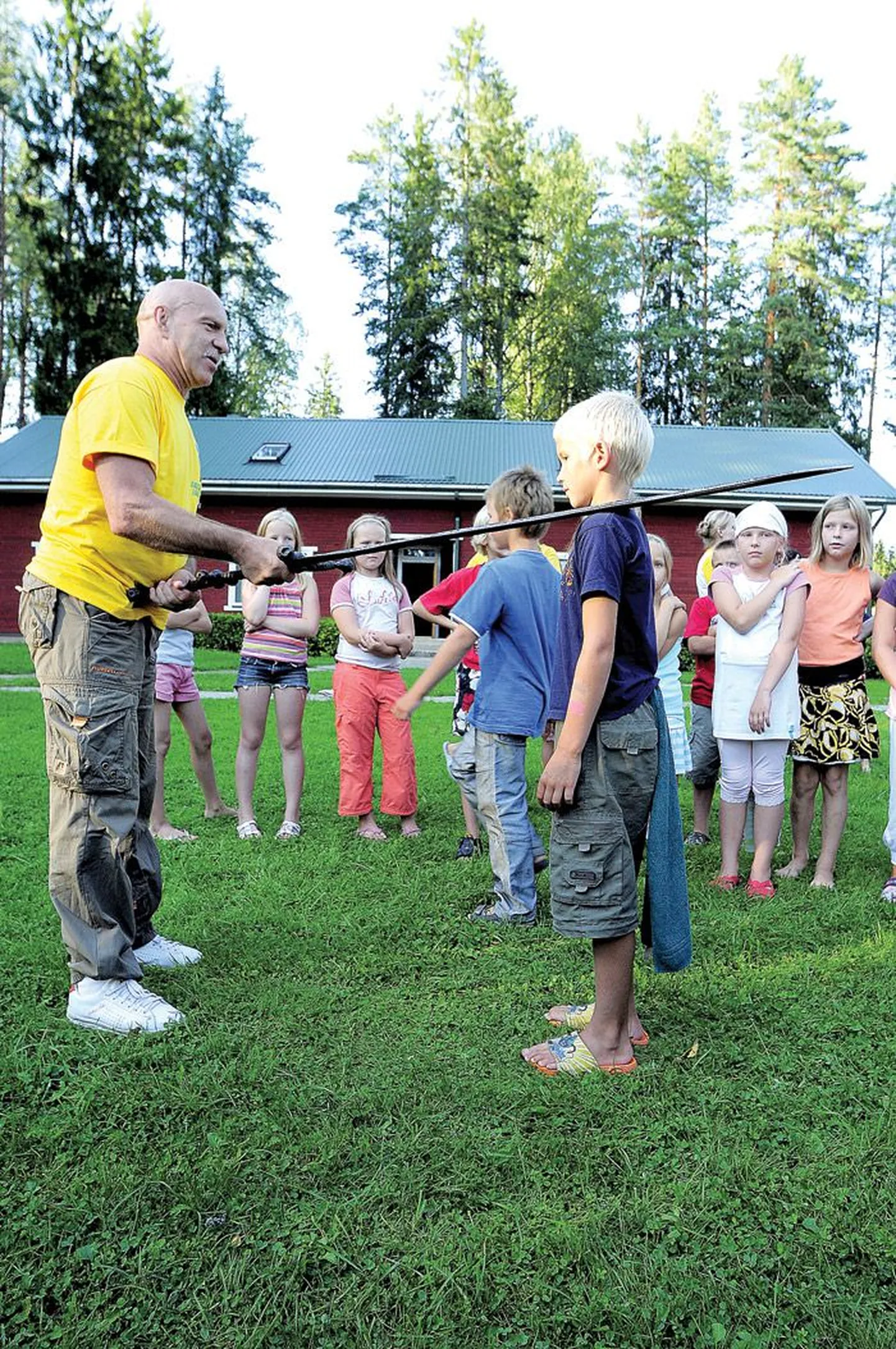 Laagriülem Voldemar Press vannutab 9-aastase Jõgevalt pärit Kristo Saveljevi kümnekilose mõõga puutega laagripere täieõiguslikuks liikmeks.
