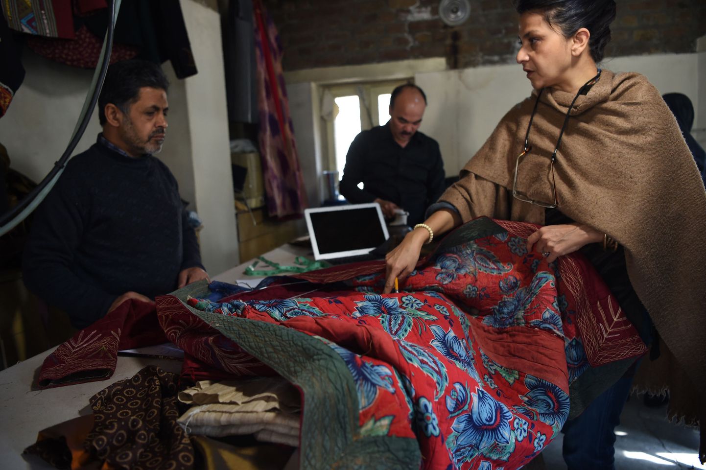 Zarifi moemaja omanik Zolaykha Sherzad (paremal) näitamas traditsioonilist chopan'i oma ettevõtte töötajatele.