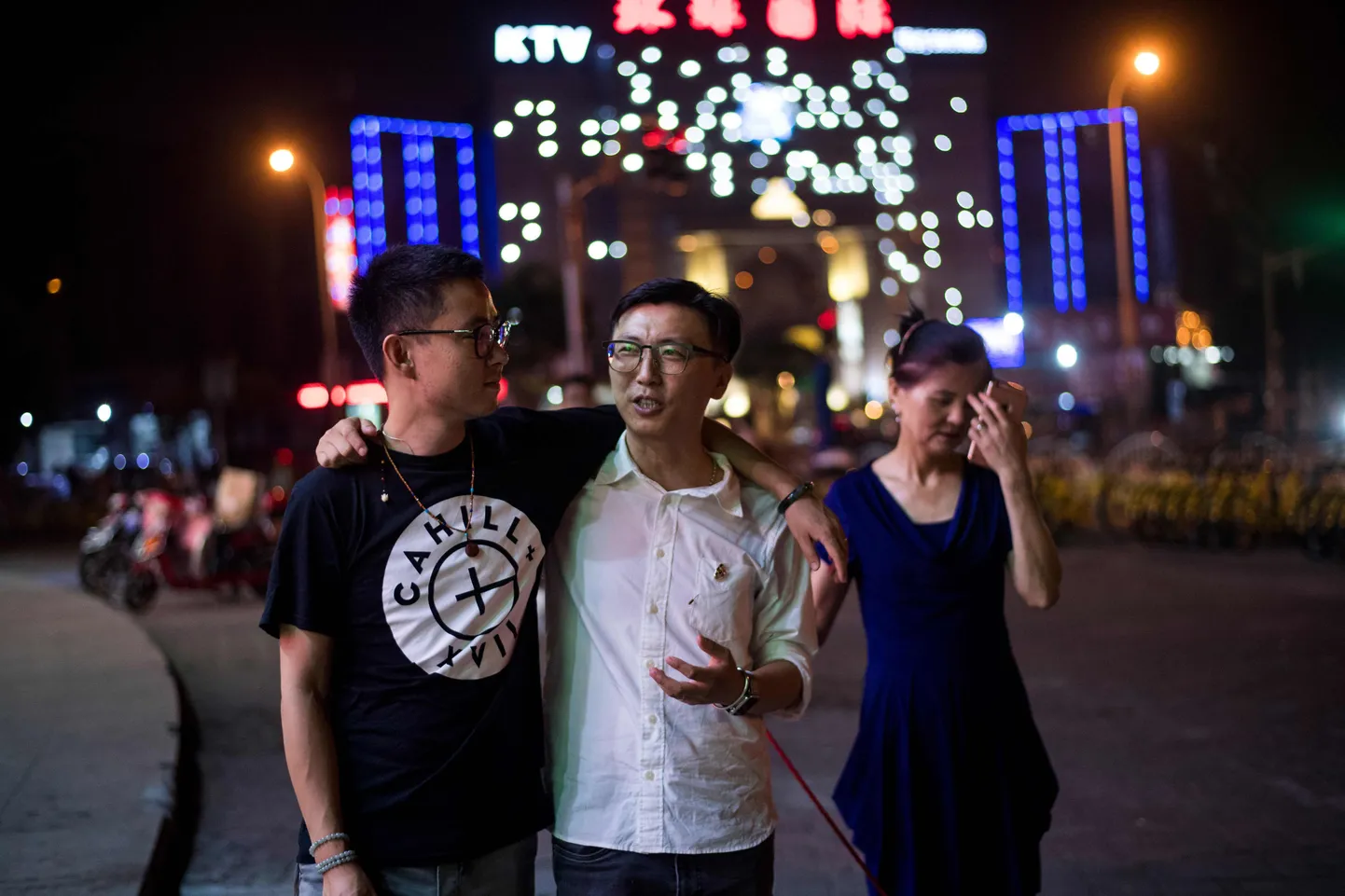 Duan Rongfeng (vasakul) ja Li Tao (keskel) Shanghais koeraga jalutamas koos Li Tao ema He Fenglanmiga.