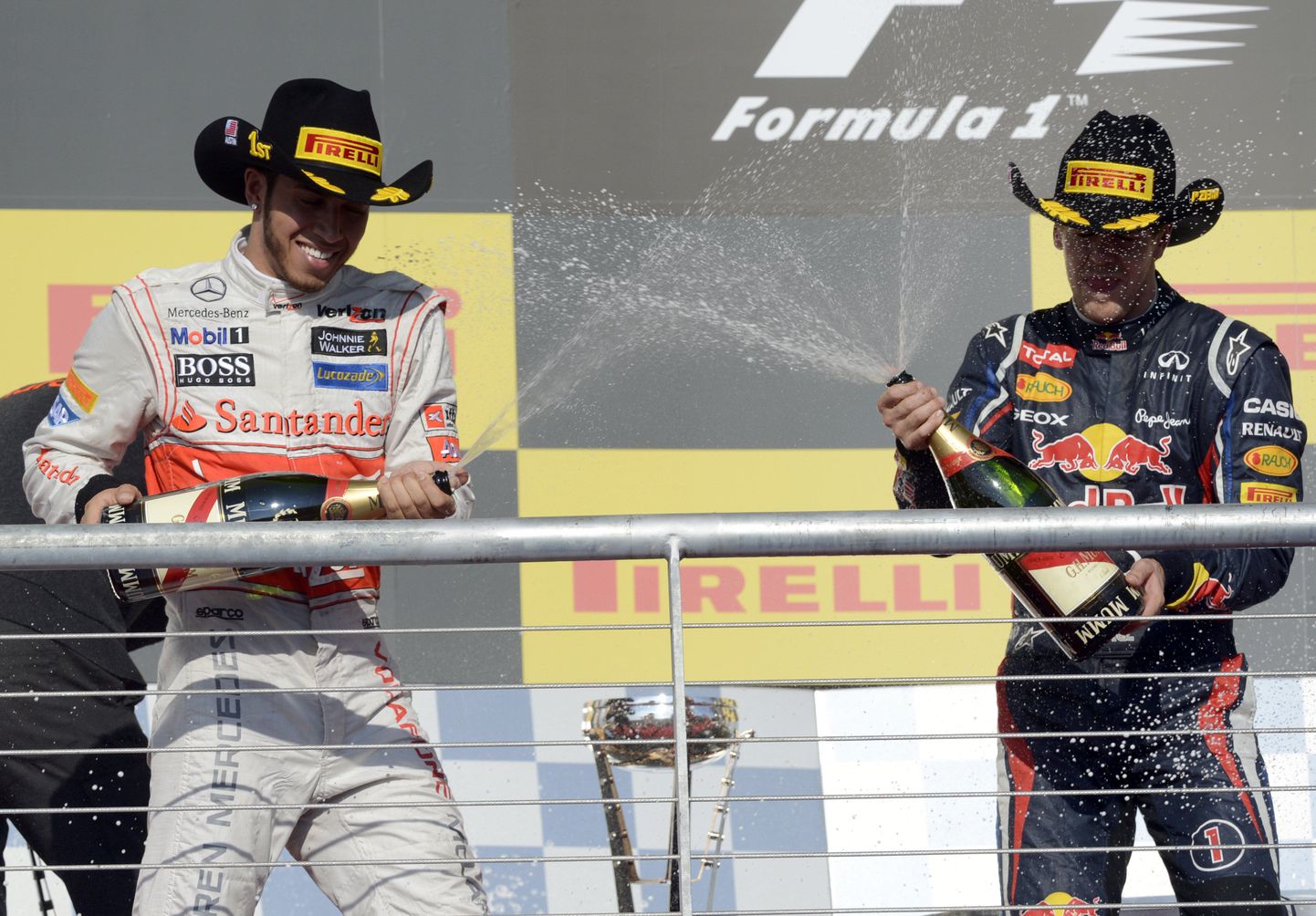 Lewis Hamilton (vasakul) ja Sebastian Vettel teineteist poodiumil šampanjaga pritsimas.