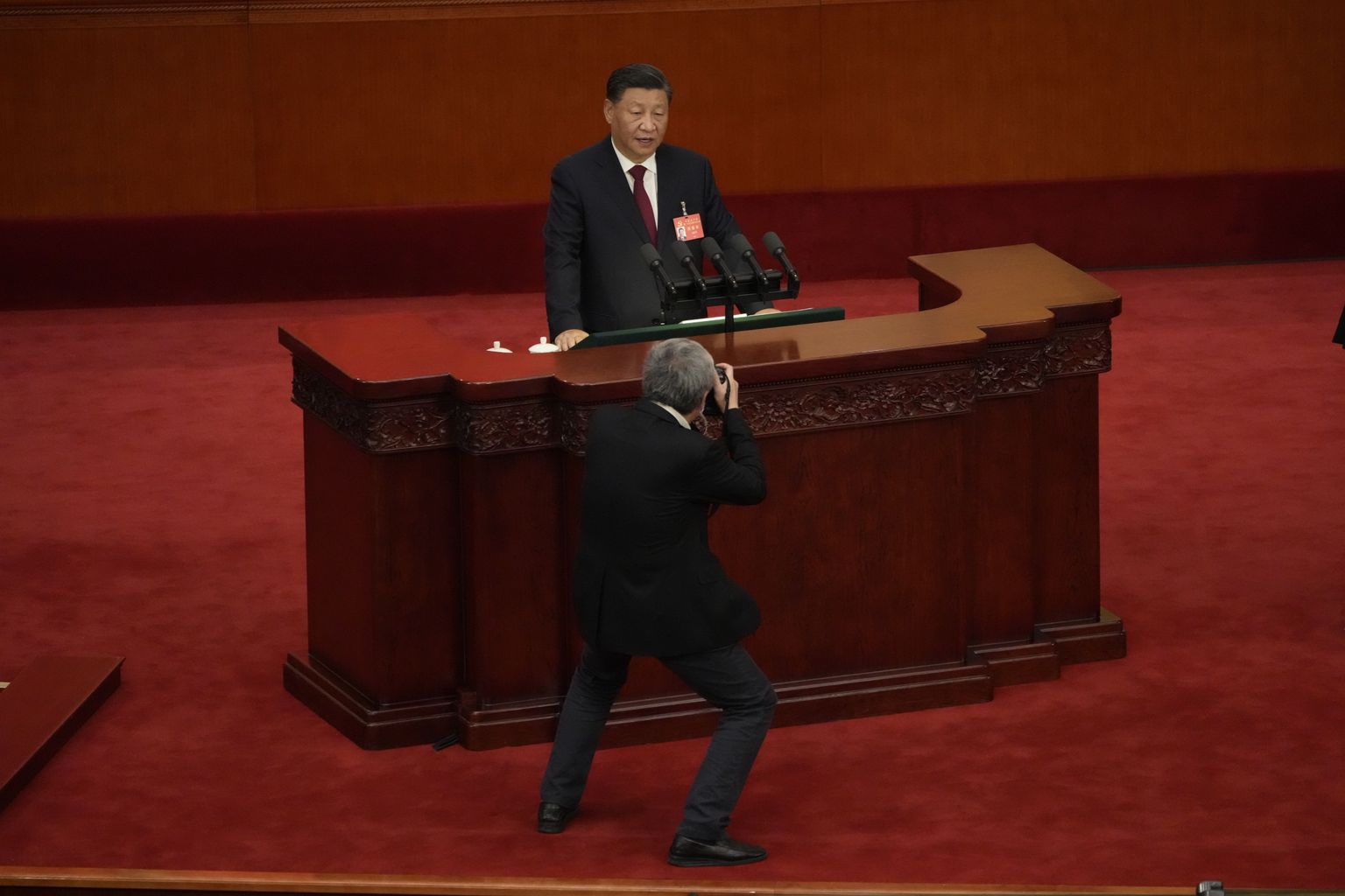 Fotograaf pildistamas Hiina liidrit Xi Jinpingi kompartei kongressi avamisel.