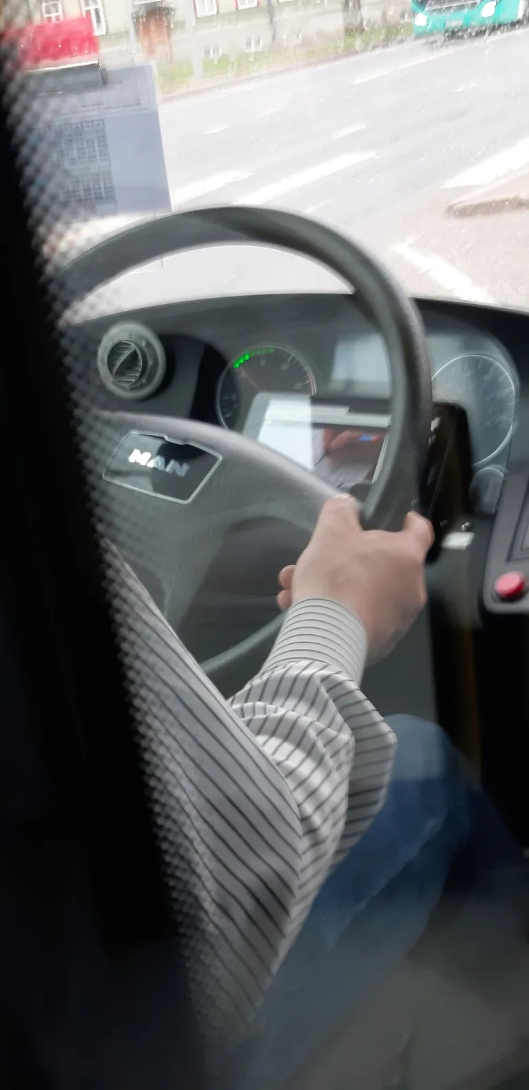 Водитель автобуса во время движения смотрел на планшете телепередачу.