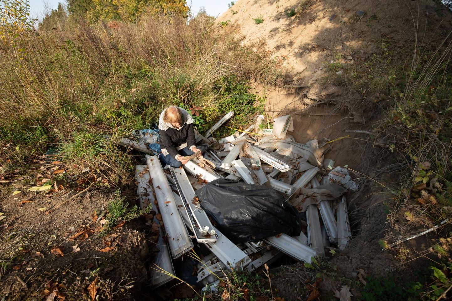 Rakvere valla heakorraspetsialist Maia Simkin püüdis Vaekülas suurde auku loobitud jäätmete hulgast leida tõendeid, mis viitaks võimalikule reostajale.