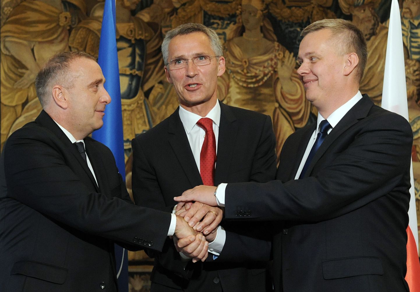 NATO peasekretär Jens Stoltenberg kätleb Poola välisinistri Grzegorz Schetyna (vasakul) ja asepeaministri ning kaitseministri Tomasz Siemoniakiga.