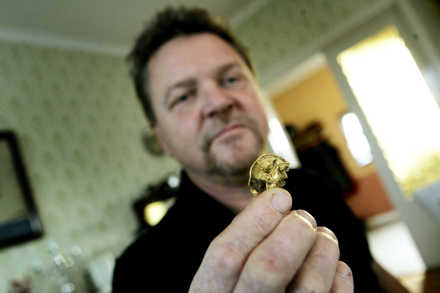 Arheoloog Georg Thomasson näitamas viikingiajastust pärit kuldsõlge