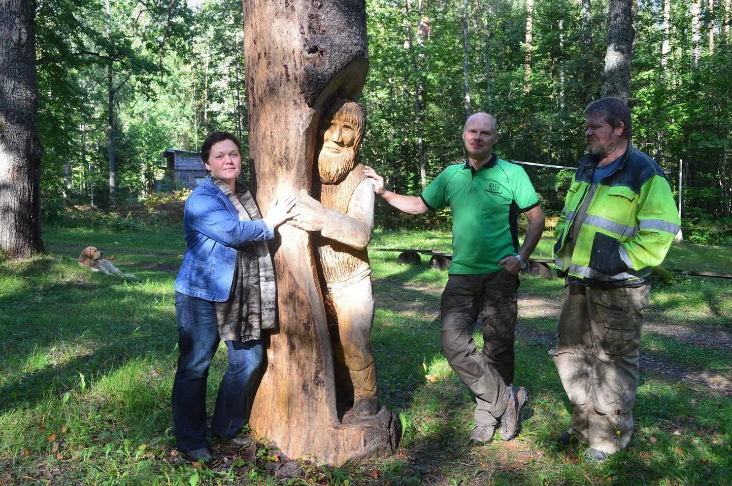 Rassi külamaja esist kaunistava vanapagana kuju juures seisavad külaseltsi asutajaliikmed Kirsti Eesmäe (vasakul), Elor Ilmet ja Aleksander Leppik.