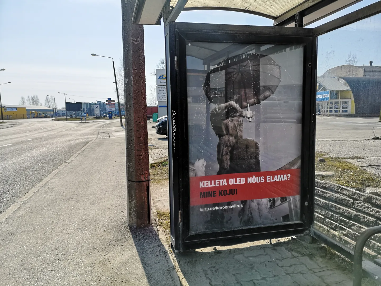 Reklaamplakat bussipeatuses Turu tänaval. Suudlevate tudengite noormees hoiab endiselt vihmavarju, tema embuses olev neiu on aga kadunud. Selle asemel hauasammas, millel surma-aasta 2020.