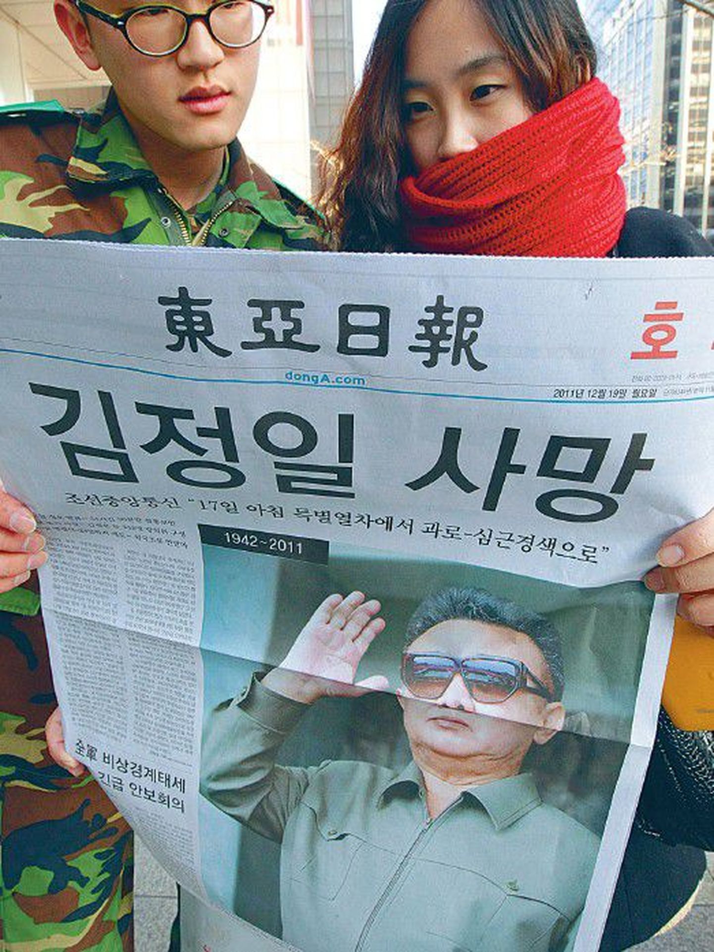 Молодые южнокорейцы читают вчерашний спецвыпуск местной сеульской газеты, в которой было опубликовано сообщение о смерти лидера соседней страны Ким Чен Ира.