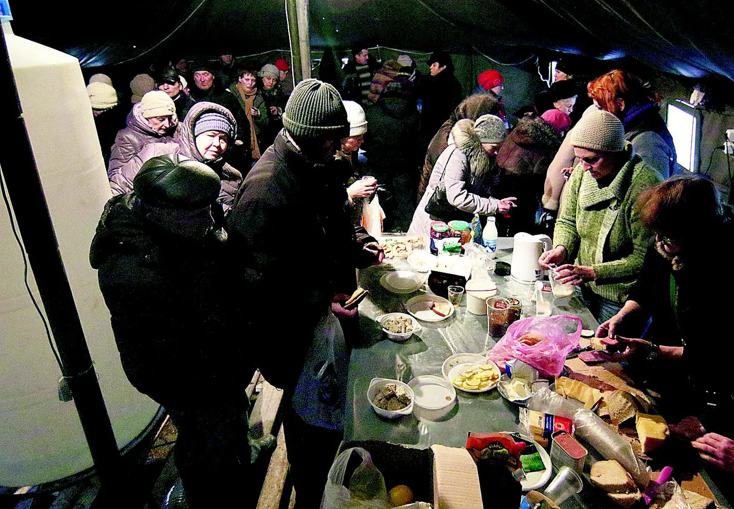 See foto on tehtud Mariupolis 25. jaanuaril. Inimesed on pärast eelmisel päeval aset leidnud raketirünnakut kogunenud suurde telki võileibu sööma ja teed jooma.