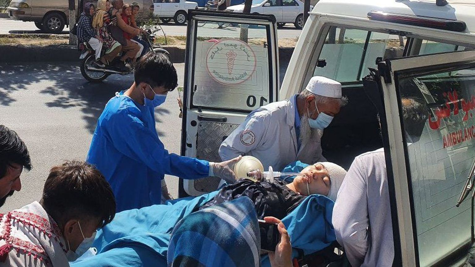 Родственники и врачи выносят раненую девочку из машины скорой помощи возле больницы в Кабуле.