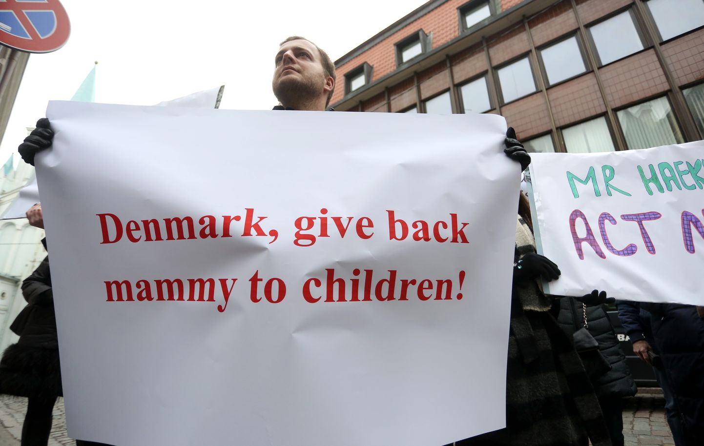 Plakāts, uz kura rakstīts "Dānija, atdod māti atpakaļ saviem bērniem!"