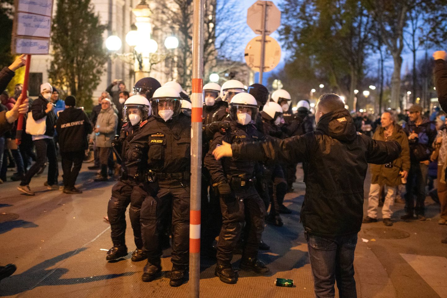 Austria politseinikud meeleavaldajate keskel.