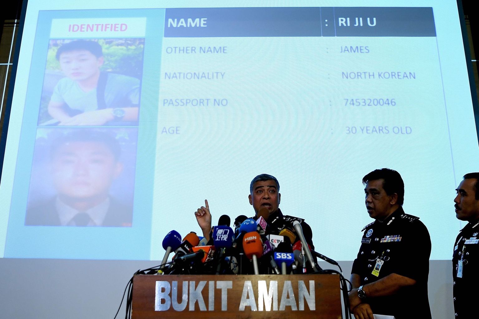Malaisia politsejuht Khalid Abu Bakar näitab pressikonverentsil kahtlusaluste fotosid.