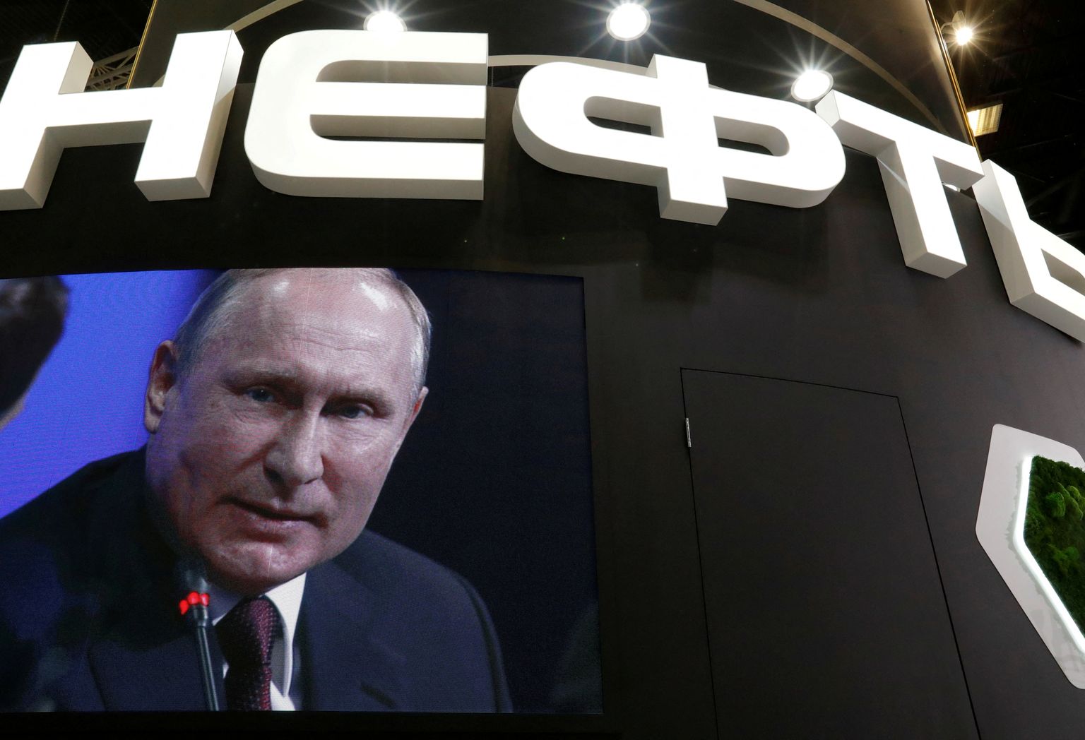 Venemaa president Vladimir Putin Rosnefti logo taustal.