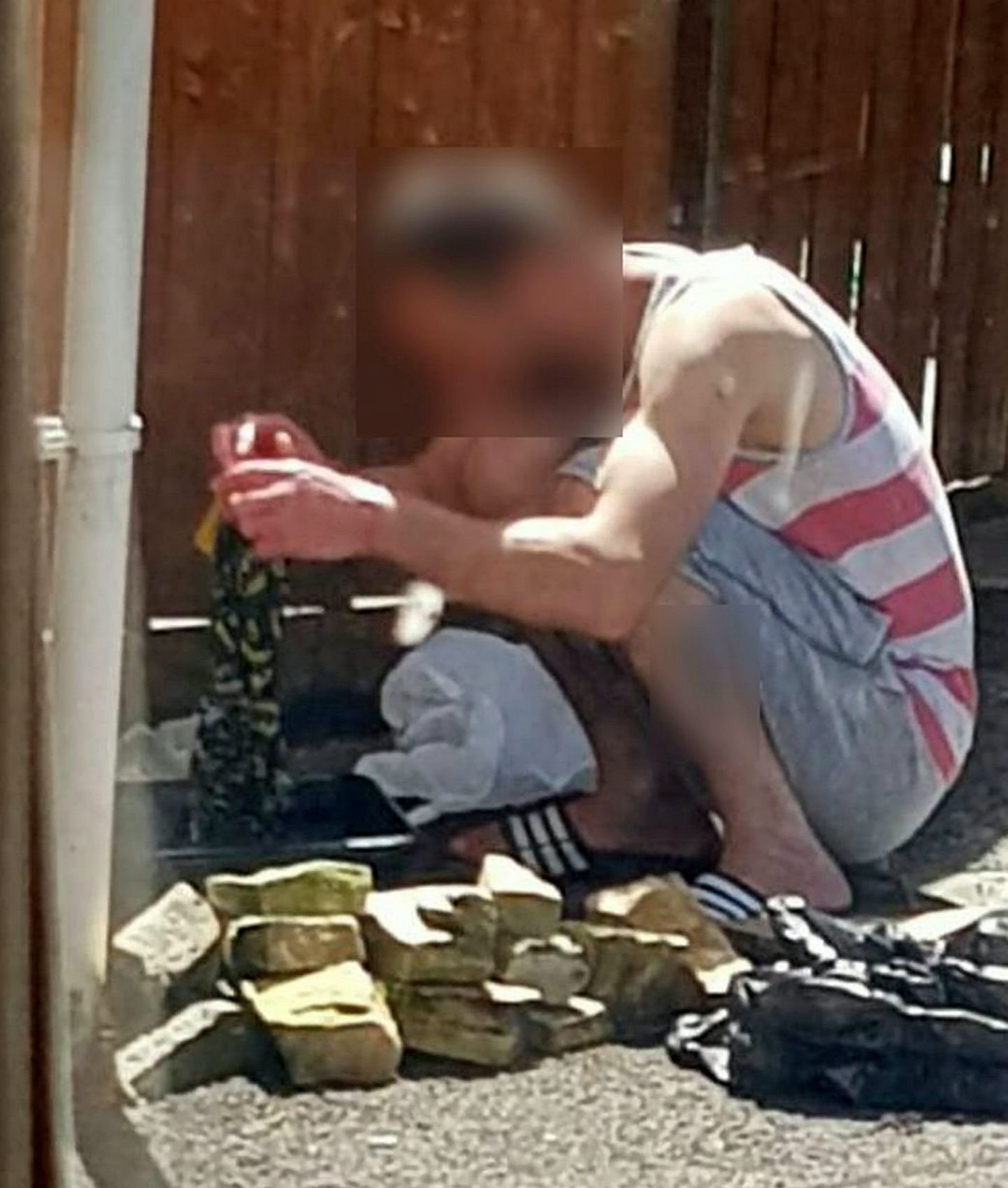 31-aastane orjastatud rumeenlane aias riideid pesemas.