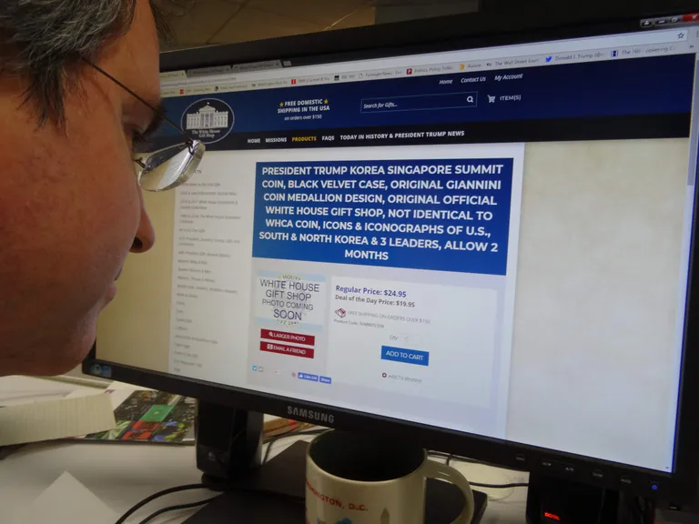Mees vaatamas Valge Maja suveniiripoe leheküljel olevat mälestusmedali eripakkumist