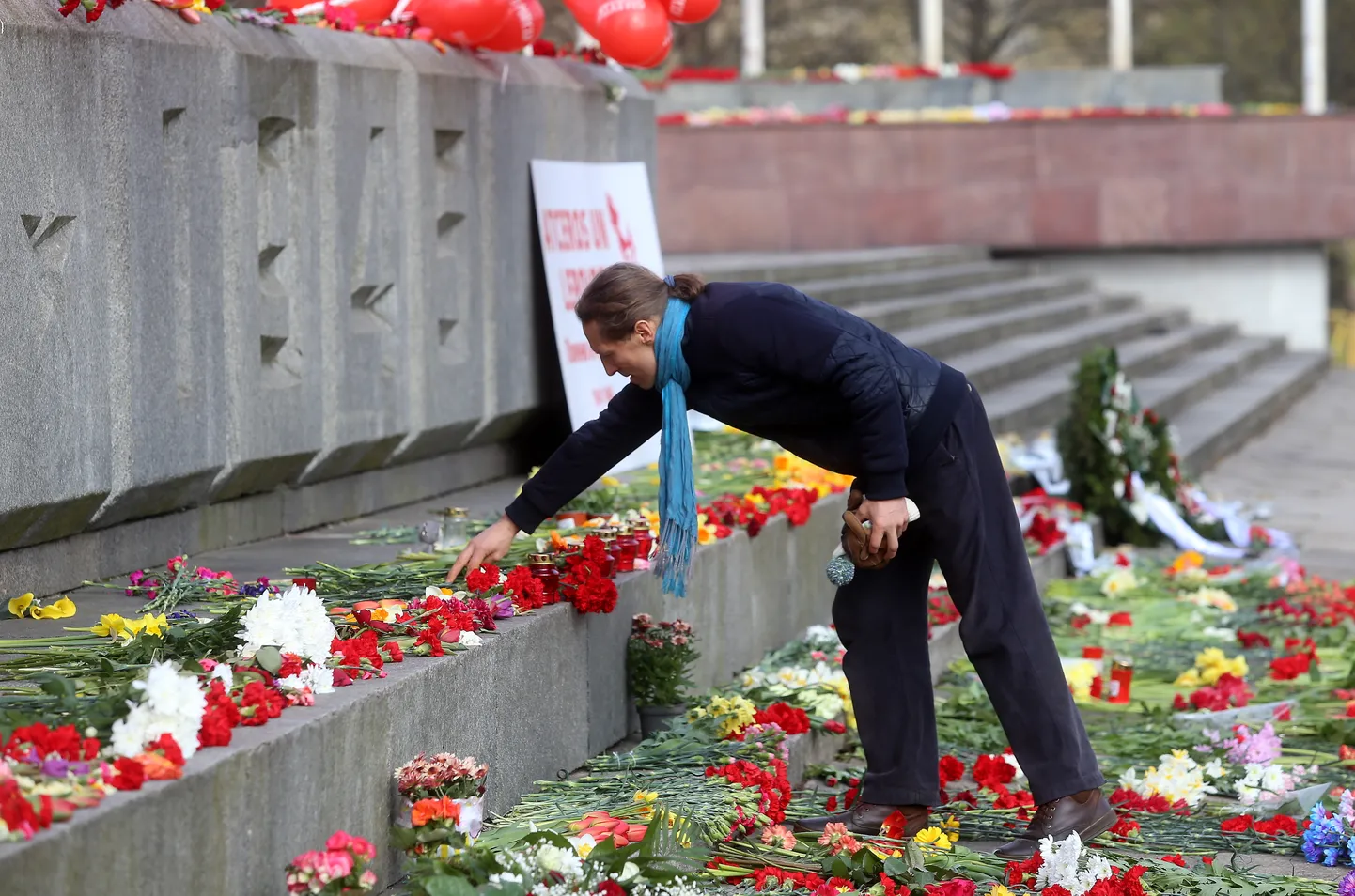 Vīrietis noliek ziedus pie pieminekļa "Padomju Latvijas un Rīgas atbrīvotājiem no nacistiskajiem iebrucējiem" Otrā pasaules kara piemiņas pasākumā Uzvaras parkā.