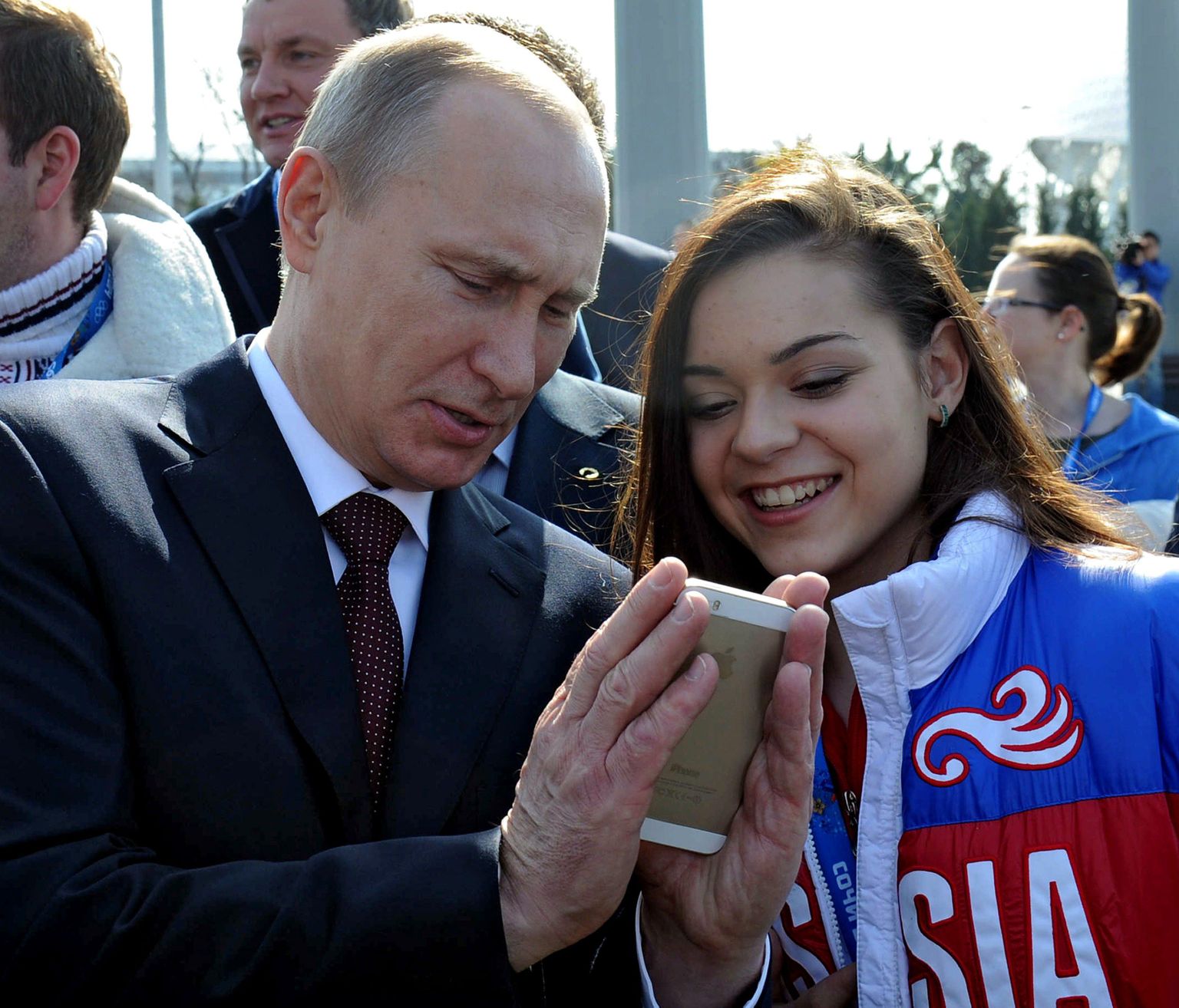 President Vladimir Putin näitab iluuisutaja Adelina Sotnikovale telefoni.