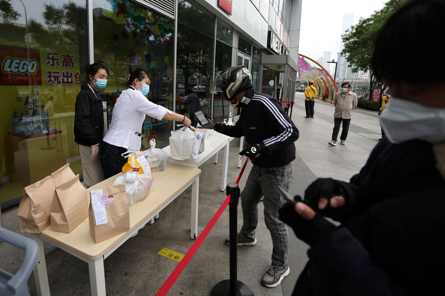Toidupakkide jagamine koroonapiirangutega Pekingis.