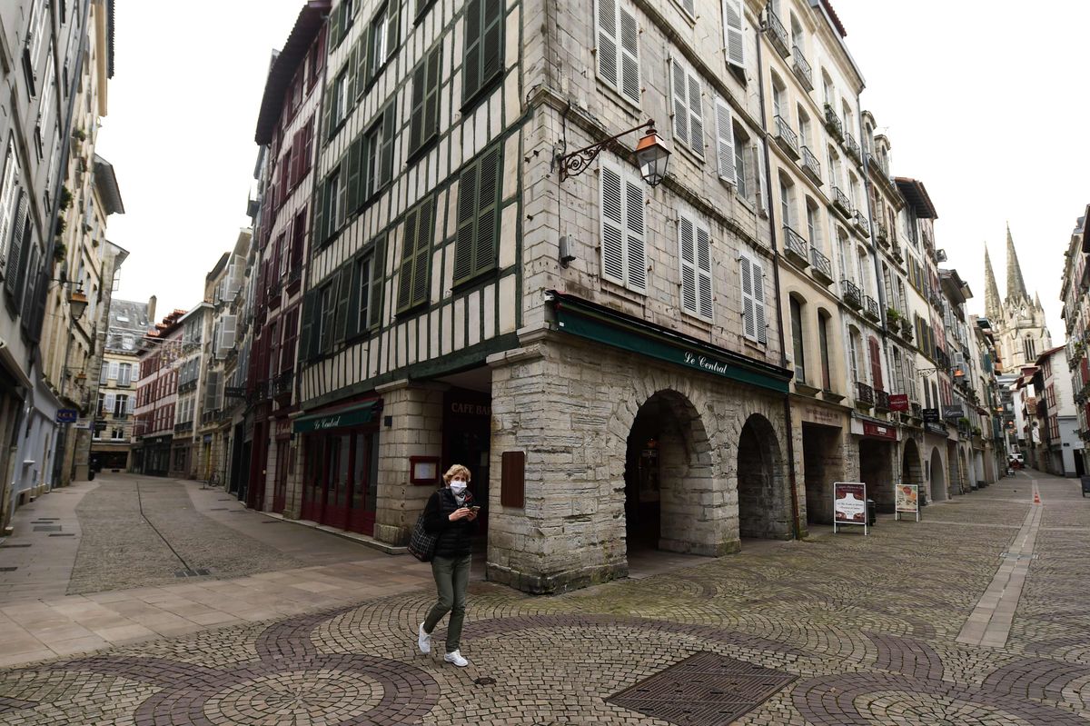 Женщина идет по пустым улицам Байонны, на юго-западе Франции, 4 ноября 2020 года.