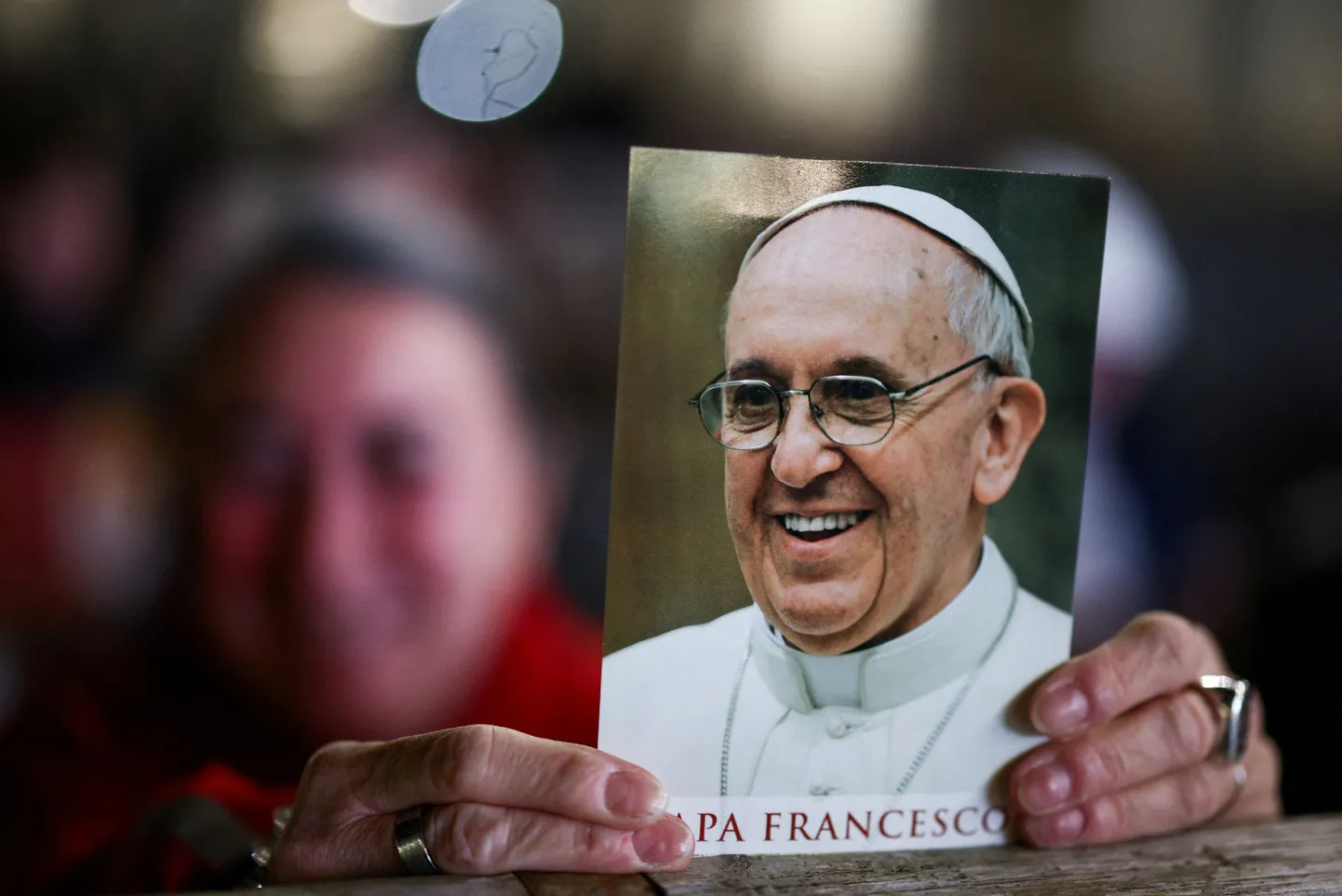 Cilvēks tur pāvesta Franciska attēlu lūgšanu dievkalpojuma dienā Svētā Pētera laukumā, kad pāvests Francisks turpina hospitalizāciju, Vatikānā, 2025. gada 19. martā.