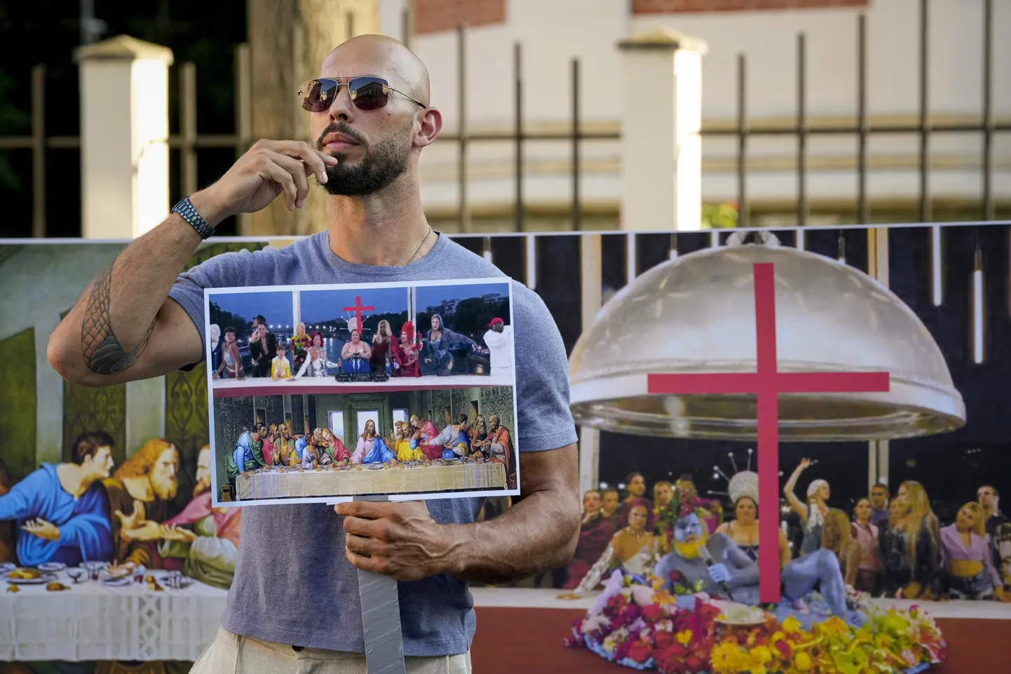 Kurikuulus suunamudija Andrew Tate protestimas Rumeenias Pariisi OM avatseremoonia vastu topellpildiga, millest ühel on Leonardo da Vinci maal ja teisel osa avatseremooniast.