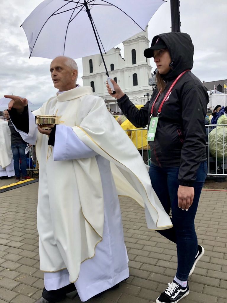 Католический священник обходит собравшихся в Аглоне