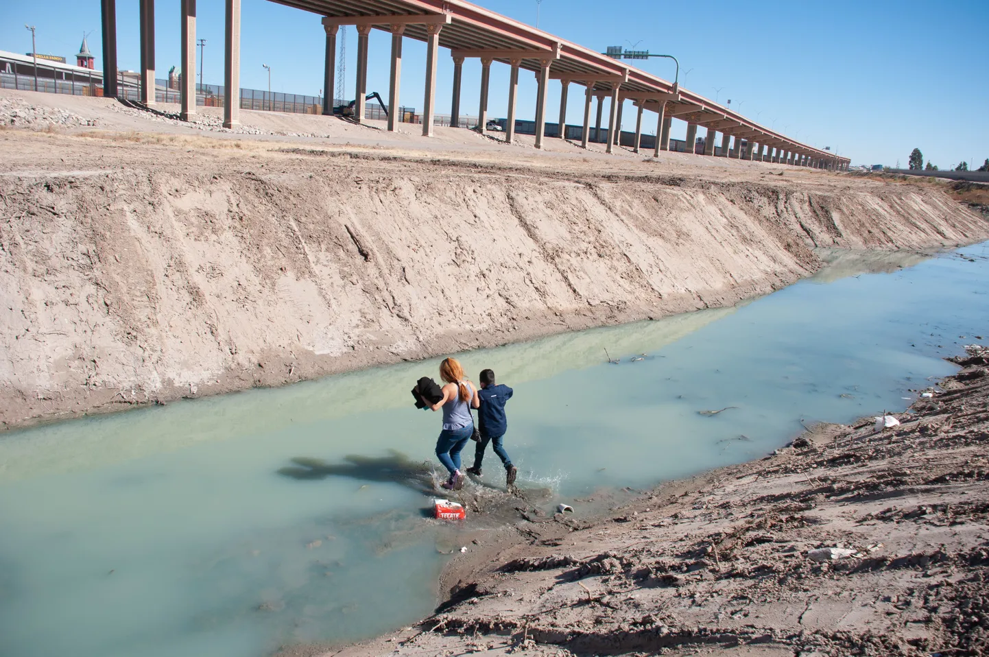 Kesk-Ameerika päritolu naine oma pojaga ületavad Rio Grande jõge USA-Mehhiko piiril.