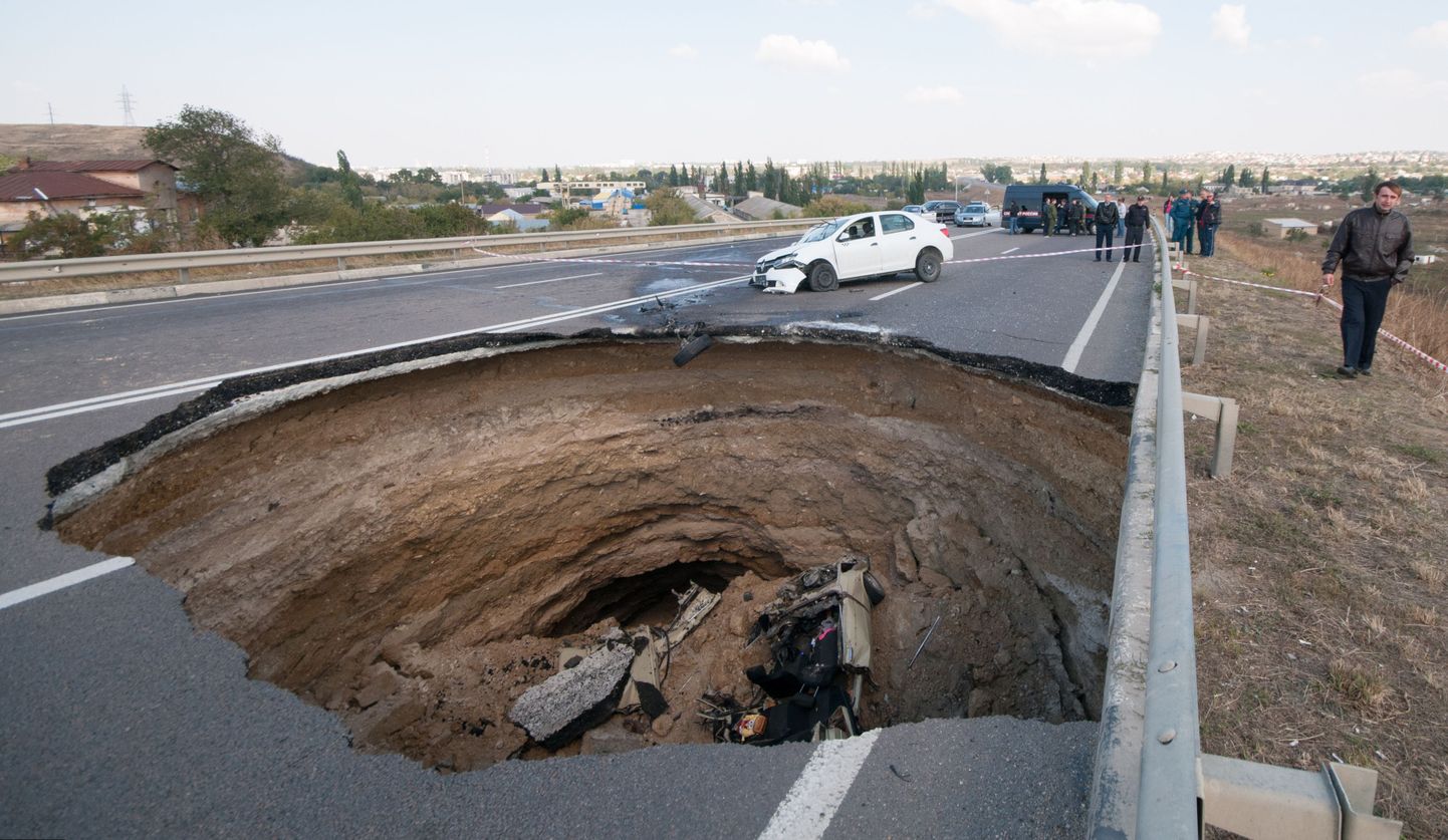 Jevpatoriat ja Nikolajevkat ühendavale maanteelõigule tekkinud 8-meetrise neeluaugu põhjas paistab sõiduauto VAZ vrakk.