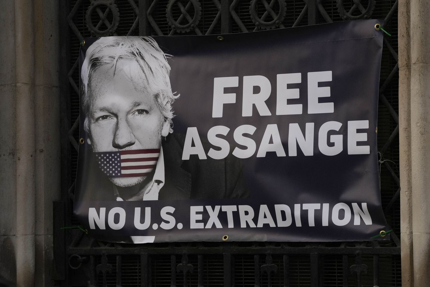 Plakat Julian Assange'i väljaandmise vastasel meeleavaldusel.