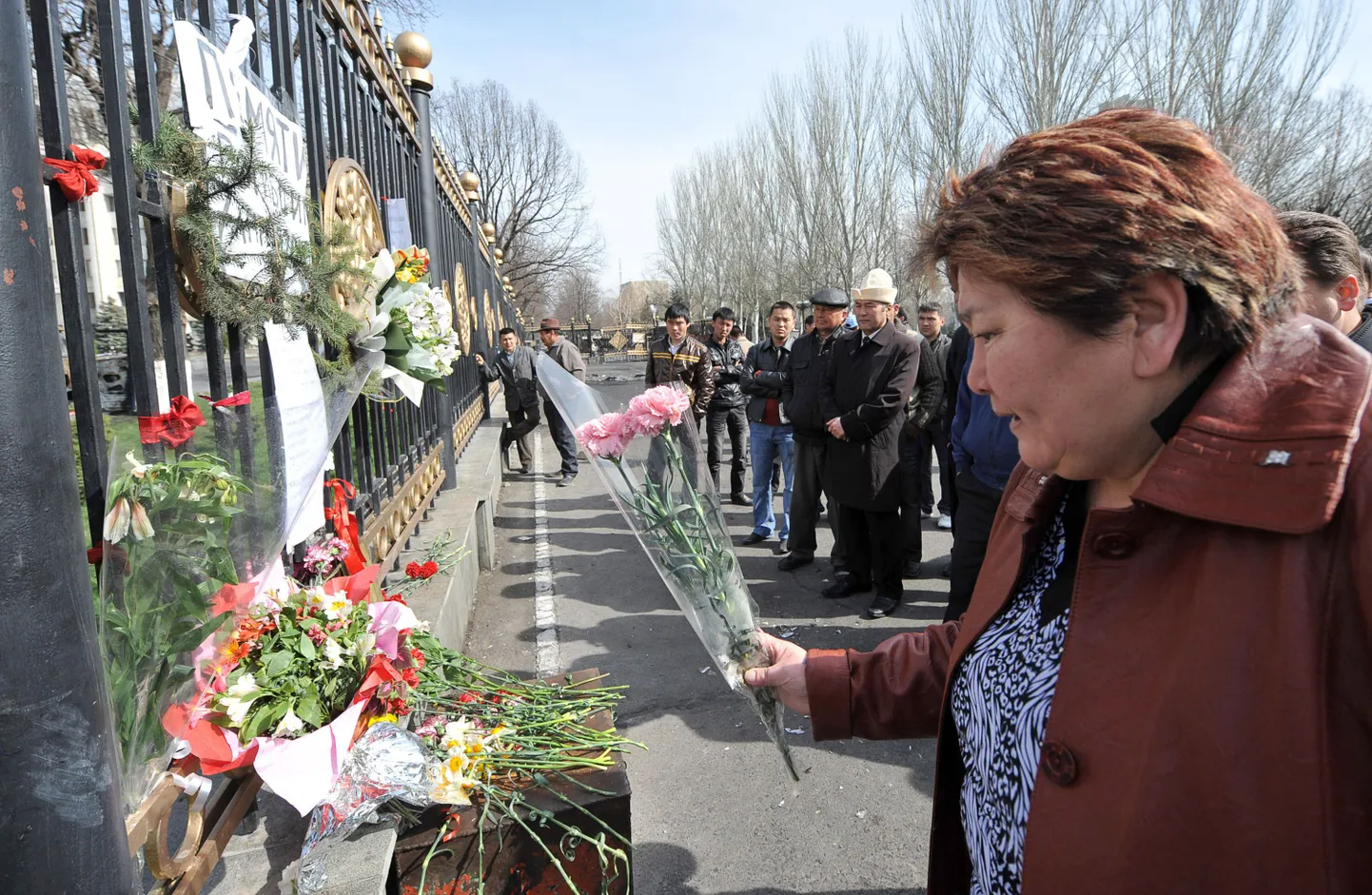 Kõrgõzstani naine asetab lilled Biškekis valitsushoone juurde, et mälestada riigipöörde käigus surma saanud kaasmaalasi.