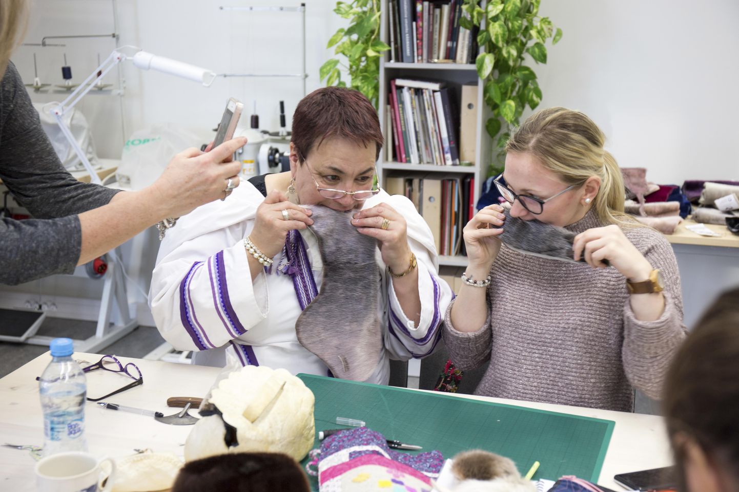 Nahameister Mona Netser (vasakul) näitas Viljandi kultuuriakadeemias õppivale Grete Küpparile, kuidas tuleb hülgenahaga ümber käia, et tekitada mütsile keskjoon. Nagu fotolt näha, tuleb selleks hambad appi võtta.