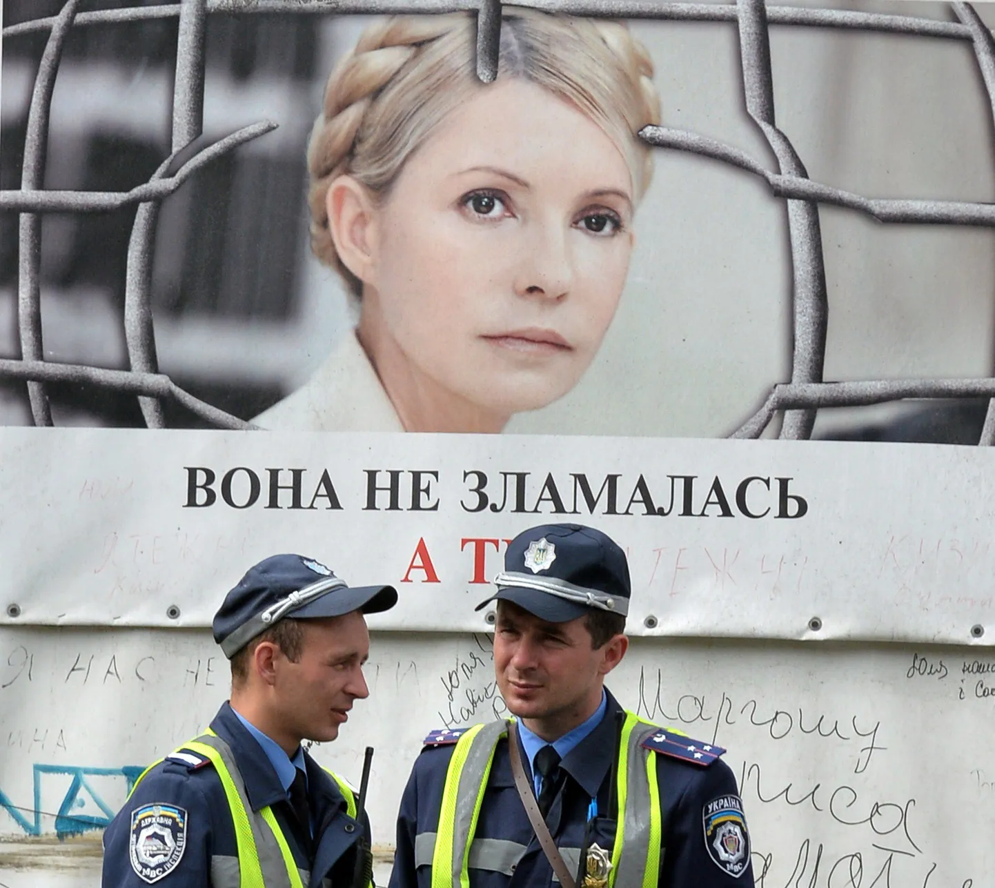 Ukraina politseinikud seisavad Kiievis Julia Tõmošenkot kujutava plakati ees «Ta pole murdunud. Aga sina?».