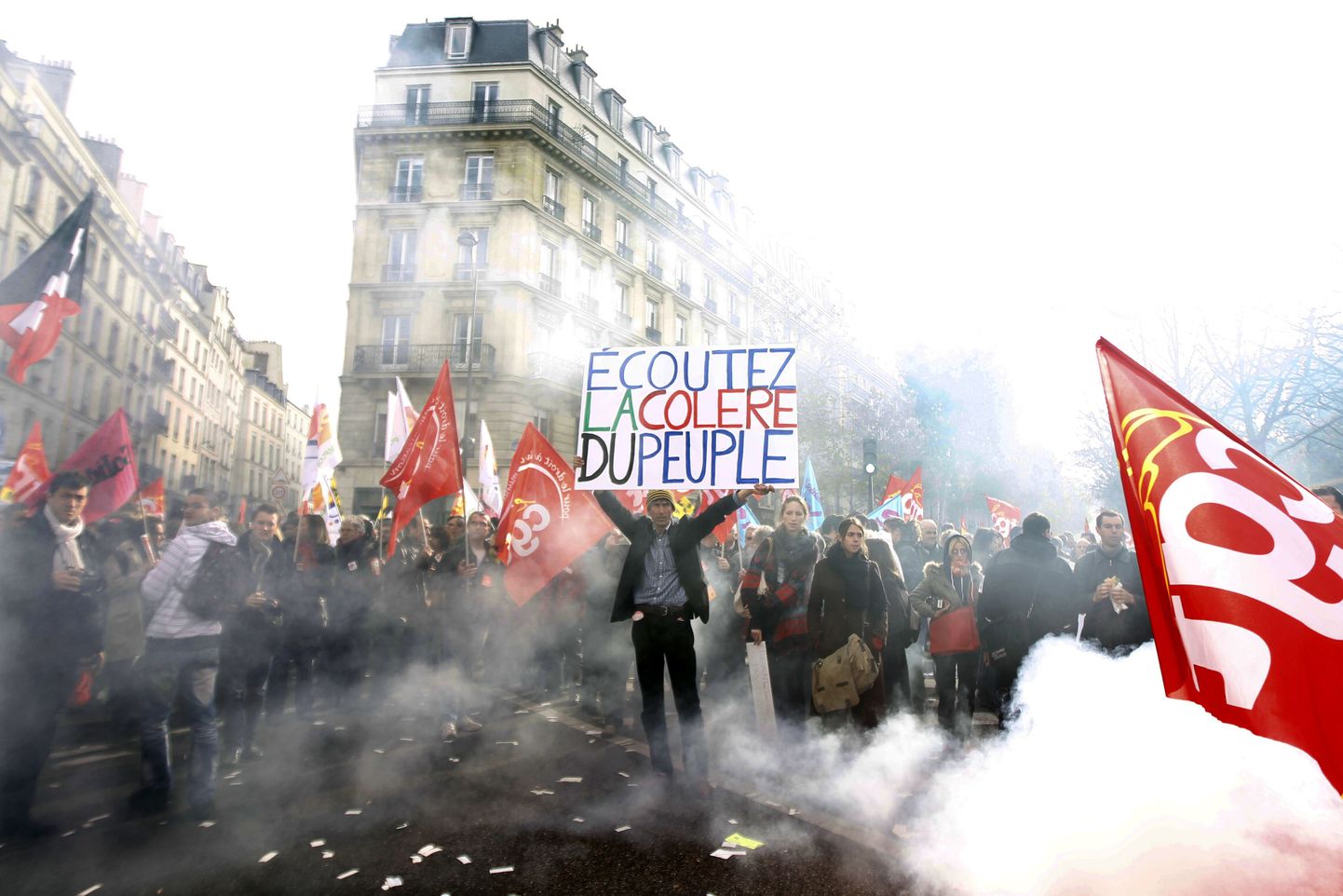 Protesteerijad Pariisi tänavatel. Mees hoidmas plakatit tekstiga: "Kuulake avalikkuse raevu".