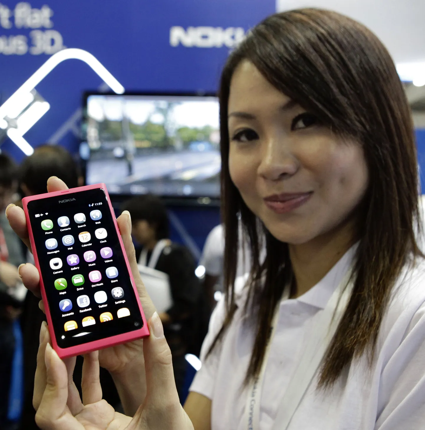 Презентация нового смартфона Nokia N9 в Сингапуре. Девушка демонстрирует дисплей устройства.